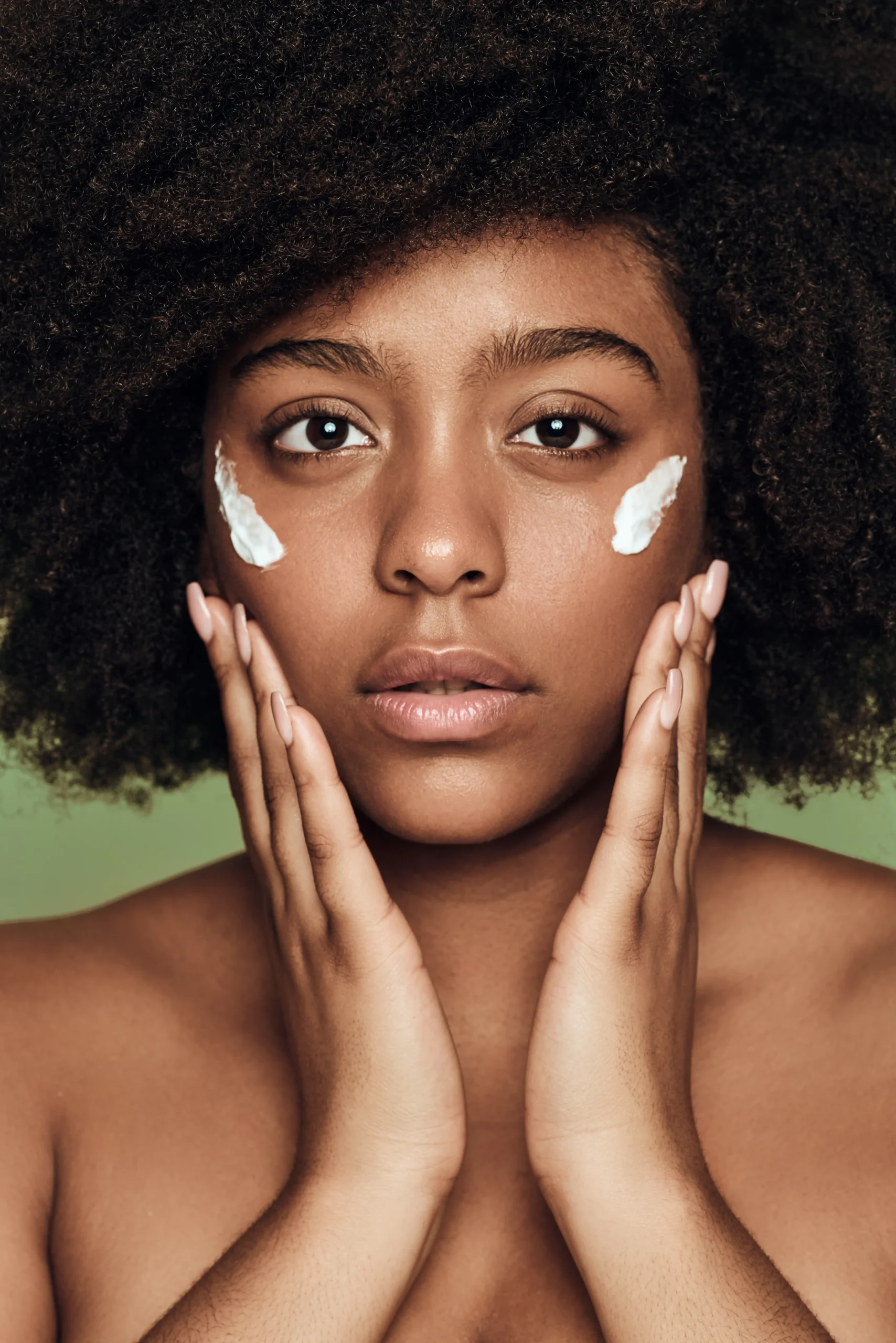 black woman applying cream on face
